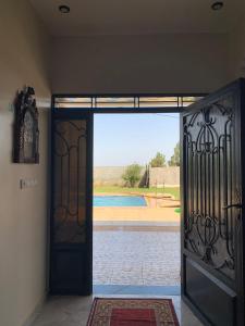 una puerta abierta con vistas a la piscina en Villa avec piscine à louer aux environs de Birjdid 46km km de Casablanca route d'El Jadida, en Bir Jedíd Saint-Hubert