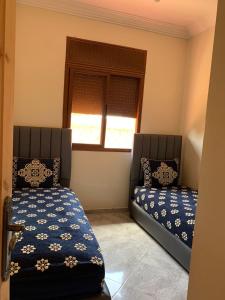 1 dormitorio con 2 camas y ventana en Villa avec piscine à louer aux environs de Birjdid 46km km de Casablanca route d'El Jadida, en Bir Jedíd Saint-Hubert