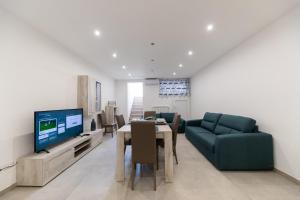 a living room with a dining table and a television at Plume Apartment by Wonderful Italy in Bari