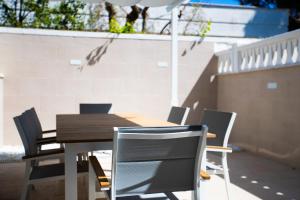 a wooden table and chairs on a patio at Plume Apartment by Wonderful Italy in Bari