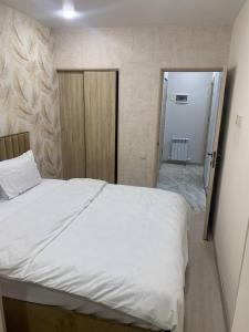 a bedroom with a white bed and a sliding door at Galstyans Home Zvartnots Airport in Pʼarakʼar