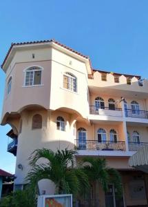 een gebouw met palmbomen ervoor bij Caribbean Paradise steps to DayPass Resort&Beach in La Laguna