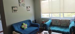 a living room with two blue chairs and a couch at Hospedaje Valdes in Puerto Montt