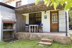 un porche de una casa con mesa y sillas en Casitas Santa Elena en Trapiche