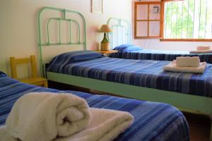Habitación con 3 camas y toallas. en Casitas Santa Elena en Trapiche