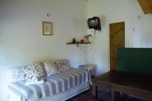 Habitación pequeña con sofá y TV. en Casitas Santa Elena en Trapiche