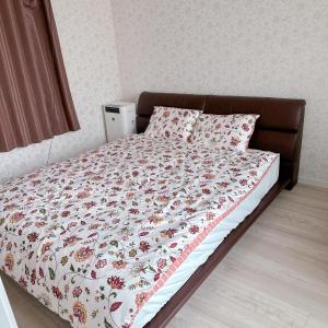 uma cama com uma colcha floral e almofadas em Free Parking Namba south Villa 4 rooms 120m2 em Osaka