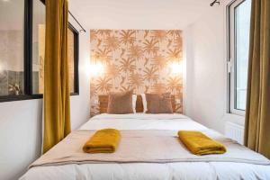 a bedroom with a bed with two yellow pillows on it at Porte MAILLOT, CHAMPS ÉLYSÉES, TRIOMPHE, suite 3 chambres 8P in Paris
