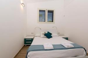 una camera da letto con un letto con due comodini e una finestra di La terrazza sul mare Porto Conte Alghero a Porto Conte