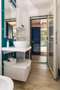 bagno con lavandino e specchio di La terrazza sul mare Porto Conte Alghero a Porto Conte