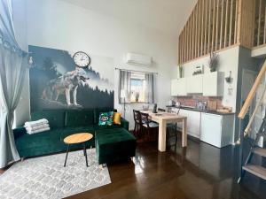 a living room with a green couch and a table at Osada Szara Wadera in Komańcza