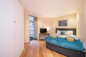 a bedroom with a large bed and a television at Pollen Street, Three-bedroom Flat in London