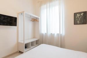 a white bedroom with a bed and a window at Duomo - Citylife Pink Vintage APT center Milan in Milan