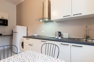 a kitchen with white cabinets and a table and a refrigerator at Duomo - Citylife Pink Vintage APT center Milan in Milan