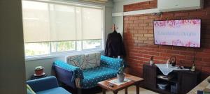 sala de estar con silla azul y pared de ladrillo en Hospedaje Valdes, en Puerto Montt