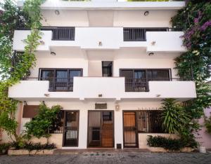 a white building with black doors and windows at Heritage Residences Santo Domingo in Santo Domingo