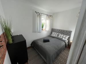 a bedroom with a bed and a black dresser at Osada Szara Wadera in Komańcza