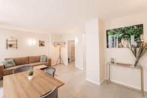 a living room with a table and a couch at Porte VERSAILLES 15eme, suite 1 chambre 2 à 4P in Paris