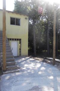 una casa amarilla con una puerta blanca y algunos árboles en Departamentos a 4 cuadras de la playa en Mar del Plata