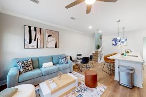 een woonkamer met een blauwe bank en een tafel bij The Primrose in Pensacola