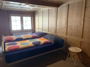 1 dormitorio con 1 cama en una pared de madera en Revier musisch und historisch, en Diesbach