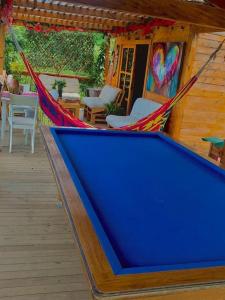 a hammock on a porch of a house at Lovely two bedroom cabin on avocado farm in Marinilla
