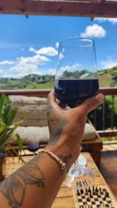 a person holding up a glass of wine at Lovely two bedroom cabin on avocado farm in Marinilla
