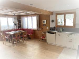 a kitchen with a table and a table and chairs at Revier Sytli im Höcheli in Braunwald