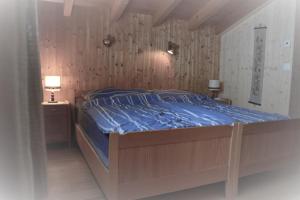 a bedroom with a bed with a blue comforter at Revier Sytli im Höcheli in Braunwald