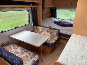 a small room with a table and chairs in a rv at Revier caravan-ig und cool in Hätzingen