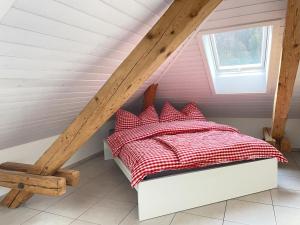 Hätzingen的住宿－Revier Attika im Hazzo，一间卧室配有一张带红色和白色棉被的床