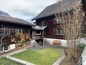 uma casa de madeira com um banco em frente em Revier Hazzo's Biasca em Hätzingen