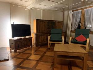uma sala de estar com 2 cadeiras e uma televisão de ecrã plano em Revier Hazzo's Biasca em Hätzingen