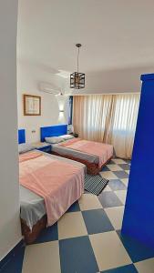 a bedroom with two beds and a checkered floor at Dahab Vibes Hotel in Dahab