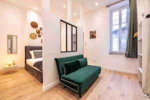 een slaapkamer met een bed en een groene stoel bij VIEUX PORT, FÉRREOL 6ème, appartement 8 personnes in Marseille