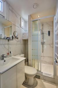 a white bathroom with a toilet and a shower at Huni Hôtel in Paris