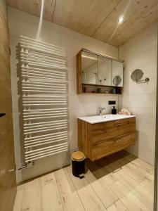 a bathroom with a sink and a mirror at Bäumers Retreat - Das Aktiv- & Regenerationsjuwel in Bad Hindelang