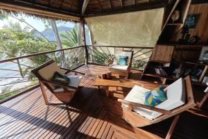 a room with chairs and a table on a deck at Nosy Komba Lodge in Nosy Komba