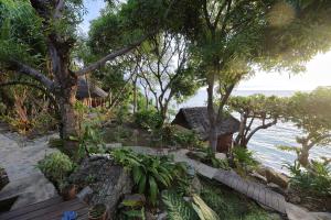 a resort on the beach with trees and the ocean at Nosy Komba Lodge in Nosy Komba