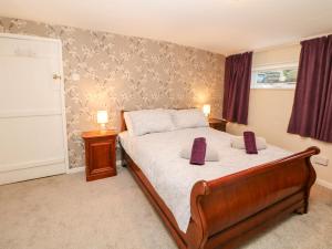 Un dormitorio con una cama y dos lámparas sobre mesas. en Wilson Eyre Cottage, en Castleton