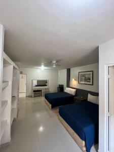 Habitación de hotel con 2 camas y TV en BED BED HOTEL CORREGIDORA, en Torreón