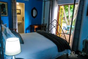 Gypsy Guest House Clarens في كلارينس: غرفة نوم بسرير وباب للباحة