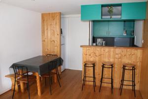 a kitchen with a table and some bar stools at Les Balcons de la Meije in La Grave