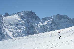 two people skiing down a snow covered mountain at Les Balcons de la Meije in La Grave