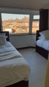 - une chambre avec 2 lits et une grande fenêtre dans l'établissement Opulent 4 bed house with parking, à Manchester