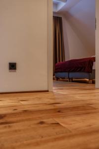 Habitación vacía con sofá y suelo de madera. en Anne + Liese Haus, en Lilienthal