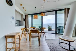 a kitchen and dining room with a table and chairs at Wave Panorama Apartment - Sea View&SPA in Międzyzdroje