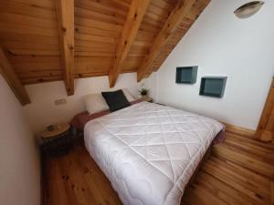 sypialnia z dużym łóżkiem na poddaszu w obiekcie Duplex en la Vall de Boí, plena naturaza w mieście Bohí