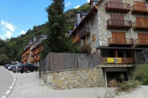 a building on the side of a street with a parking lot at Duplex en la Vall de Boí, plena naturaza in Bohí