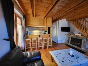 a living room with a couch and a kitchen at Duplex en la Vall de Boí, plena naturaza in Bohí